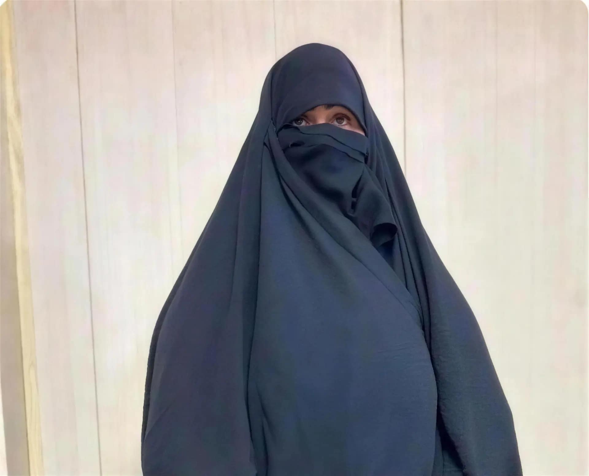 Sadiya, a widow and mother in Najaf, Iraq, wearing a dark navy niqab